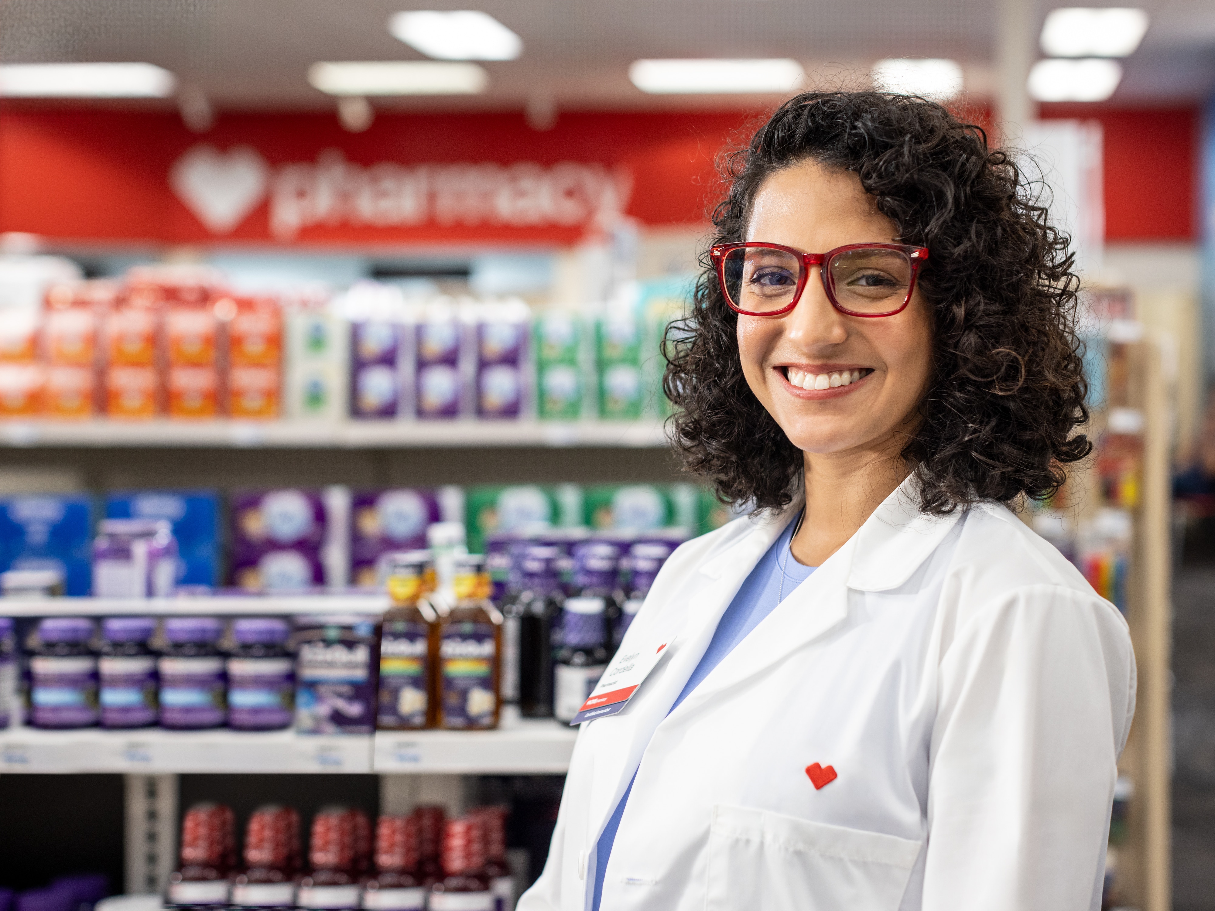 Pharmacist smiling and standing in an aisle in a CVS store