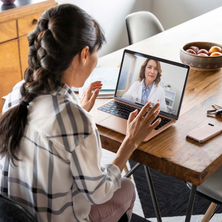 A patient uses MinuteClinic Virtual Care™ to visit with a licensed provider over video on their laptop.
